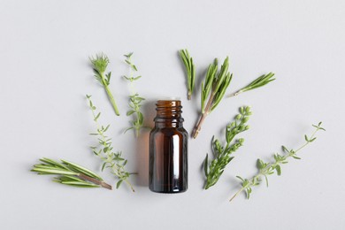 Photo of Essential oil and different plants on white background, flat lay