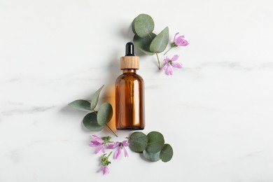 Photo of Essential oil and plants on white background, flat lay