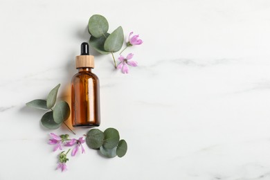Photo of Essential oil and plants on white background, flat lay. Space for text