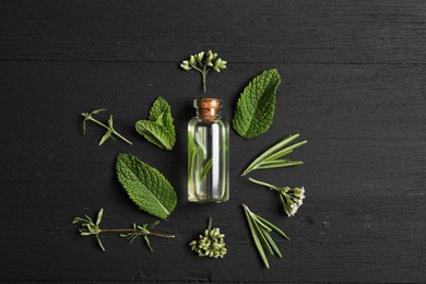 Photo of Essential oil and different plants on black wooden background, flat lay