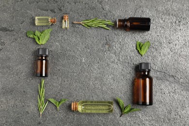 Photo of Frame of essential oils and different plants on grey background, flat lay. Space for text
