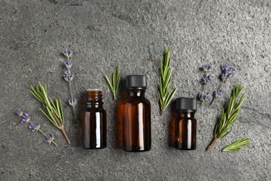 Photo of Essential oils and different plants on grey background, flat lay