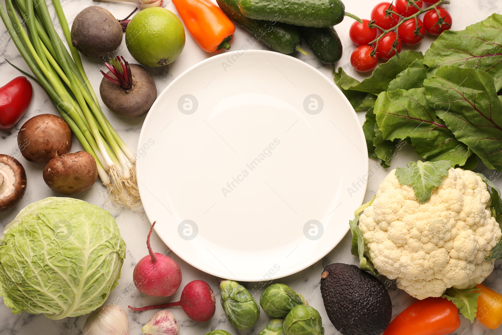 Healthy vegetarian food. Empty plate surrounded by different products on white marble table, flat lay Photo of Healthy vegetarian food. Empty plate surrounded by different products on white marble table, flat lay
