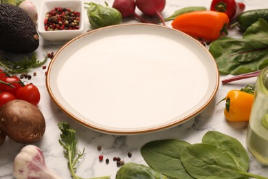 Photo of Healthy vegetarian food. Empty plate surrounded by different products on white marble table, closeup
