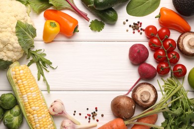 Photo of Healthy vegetarian food. Frame of different products on white wooden table, flat lay. Space for text