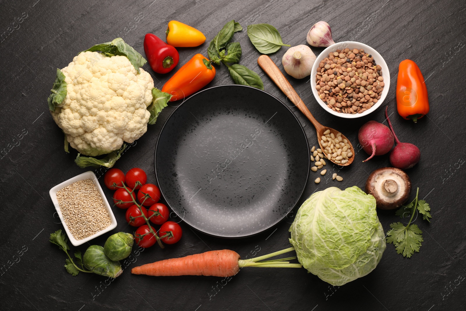 Healthy vegetarian food. Empty plate surrounded by different products on dark textured table, flat lay Photo of Healthy vegetarian food. Empty plate surrounded by different products on dark textured table, flat lay