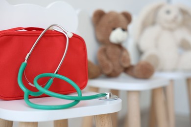 Photo of Pediatrician concept. Toys, medical bag and stethoscope on chairs in clinic, selective focus