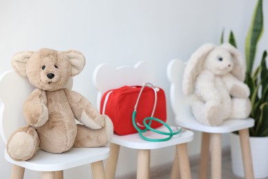 Photo of Pediatrician concept. Toys, medical bag and stethoscope on chairs in clinic