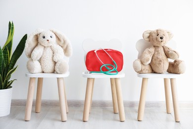 Photo of Pediatrician concept. Toys, medical bag and stethoscope on chairs in clinic
