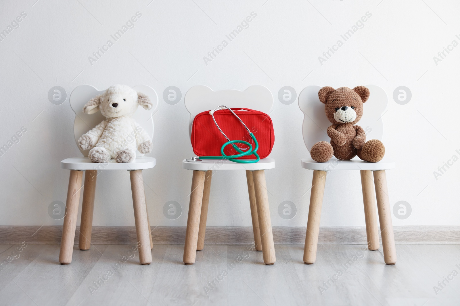 Photo of Pediatrician concept. Toys, medical bag and stethoscope on chairs in clinic