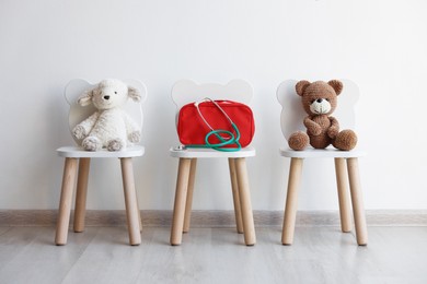 Photo of Pediatrician concept. Toys, medical bag and stethoscope on chairs in clinic