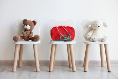 Photo of Pediatrician concept. Toys, medical bag and stethoscope on chairs in clinic