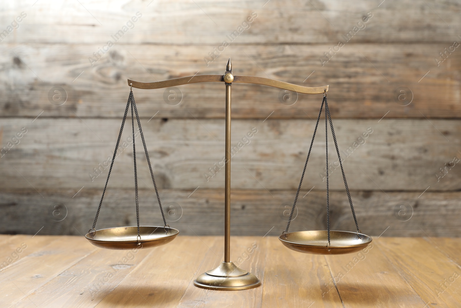 Photo of Golden scales of justice on wooden table