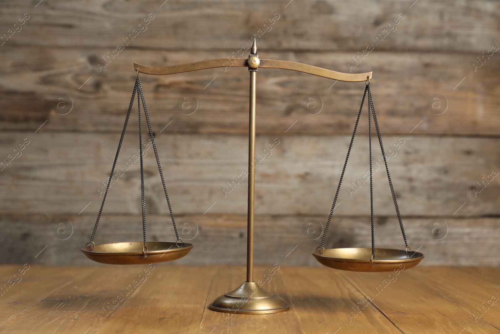 Photo of Golden scales of justice on wooden table