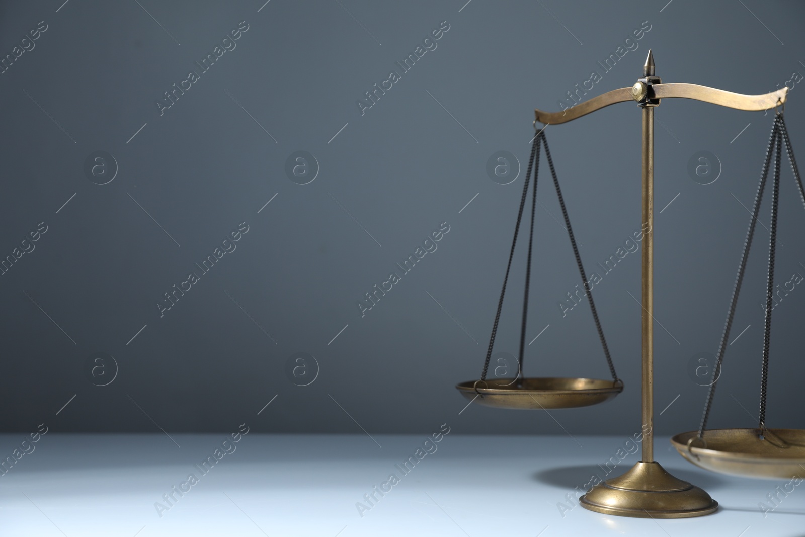 Photo of Scales of justice on grey background. Space for text