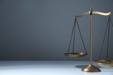 Photo of Scales of justice on grey background. Space for text