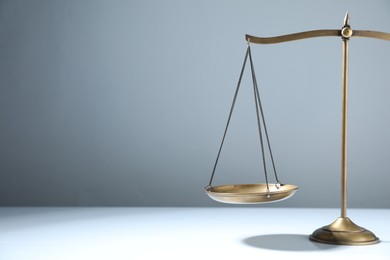 Photo of Scales of justice on grey background. Space for text