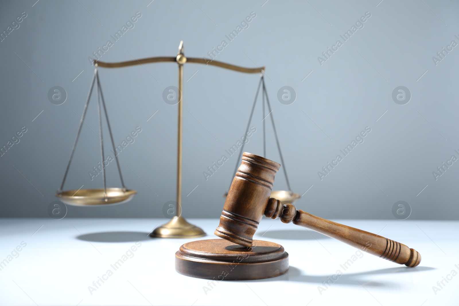 Photo of Gavel and scales of justice on grey background, selective focus