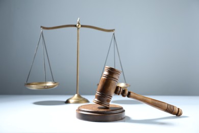 Photo of Gavel and scales of justice on grey background, selective focus