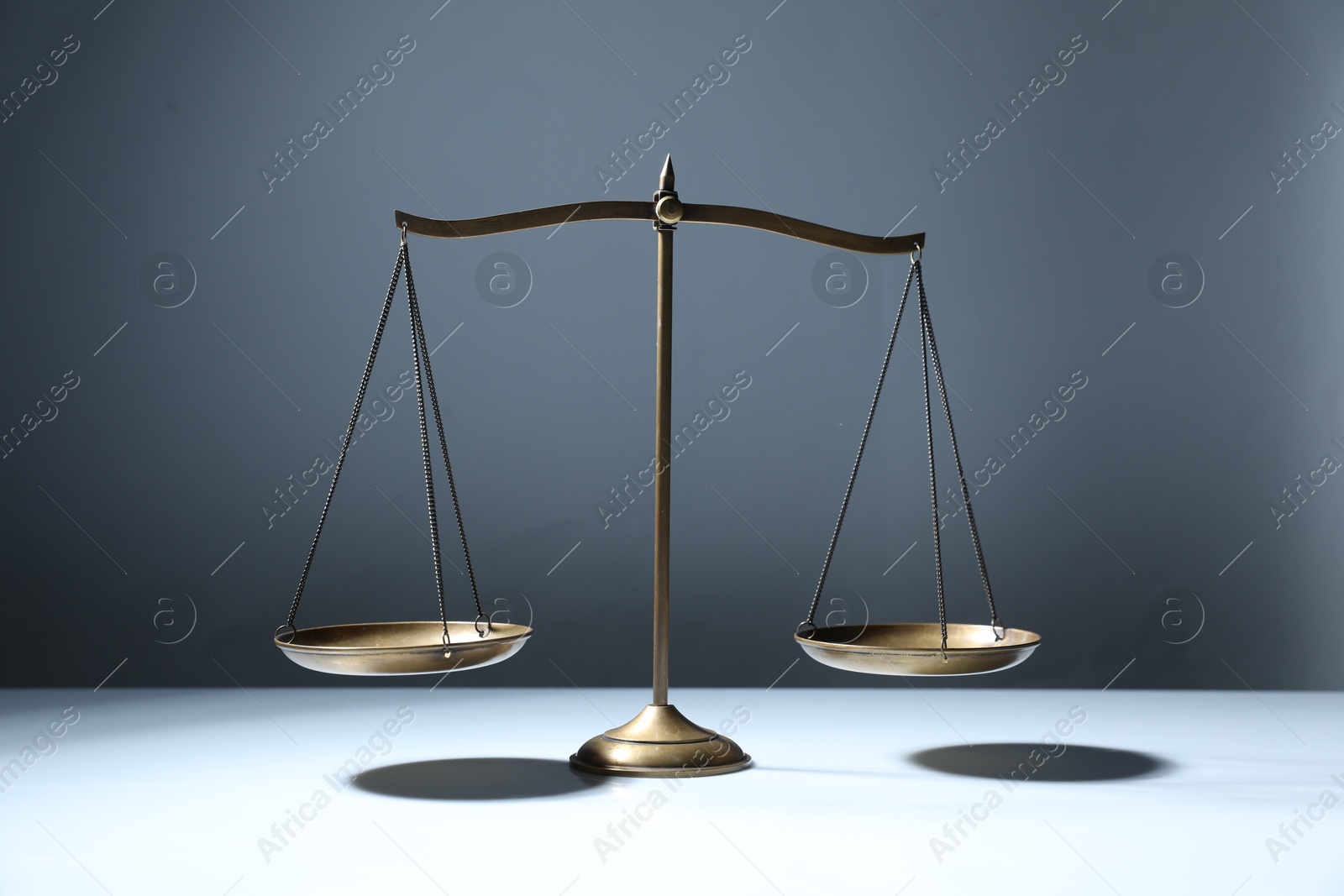 Photo of Golden scales of justice on grey background