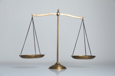 Photo of Scales of justice on light grey background