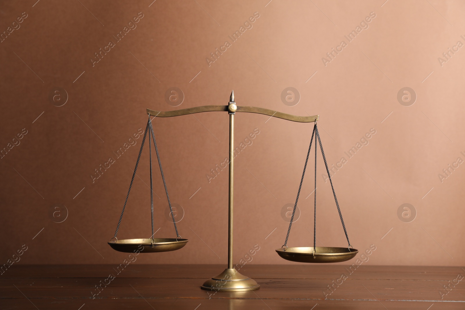 Photo of Golden scales of justice on wooden table