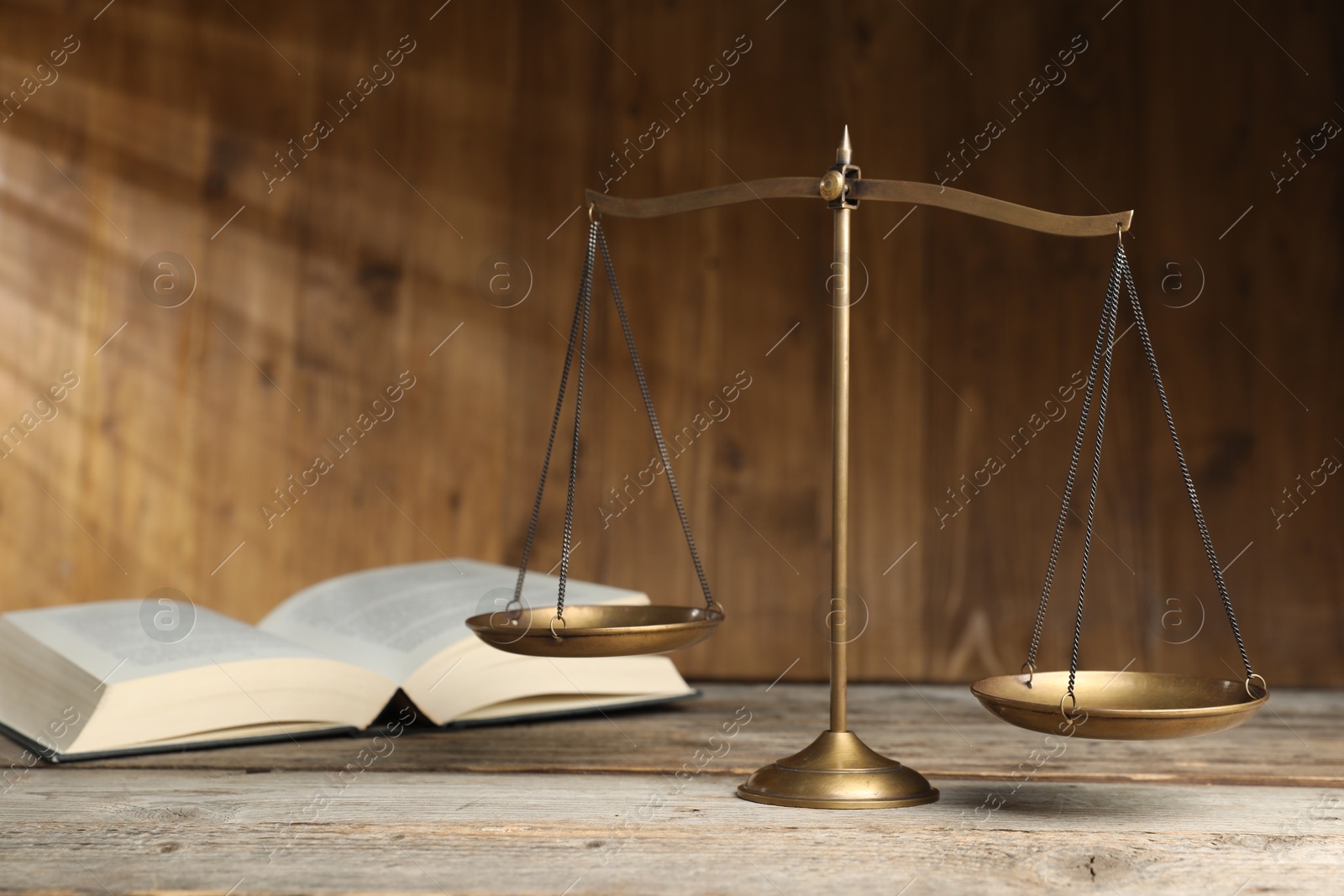Photo of Scales of justice and book on wooden table