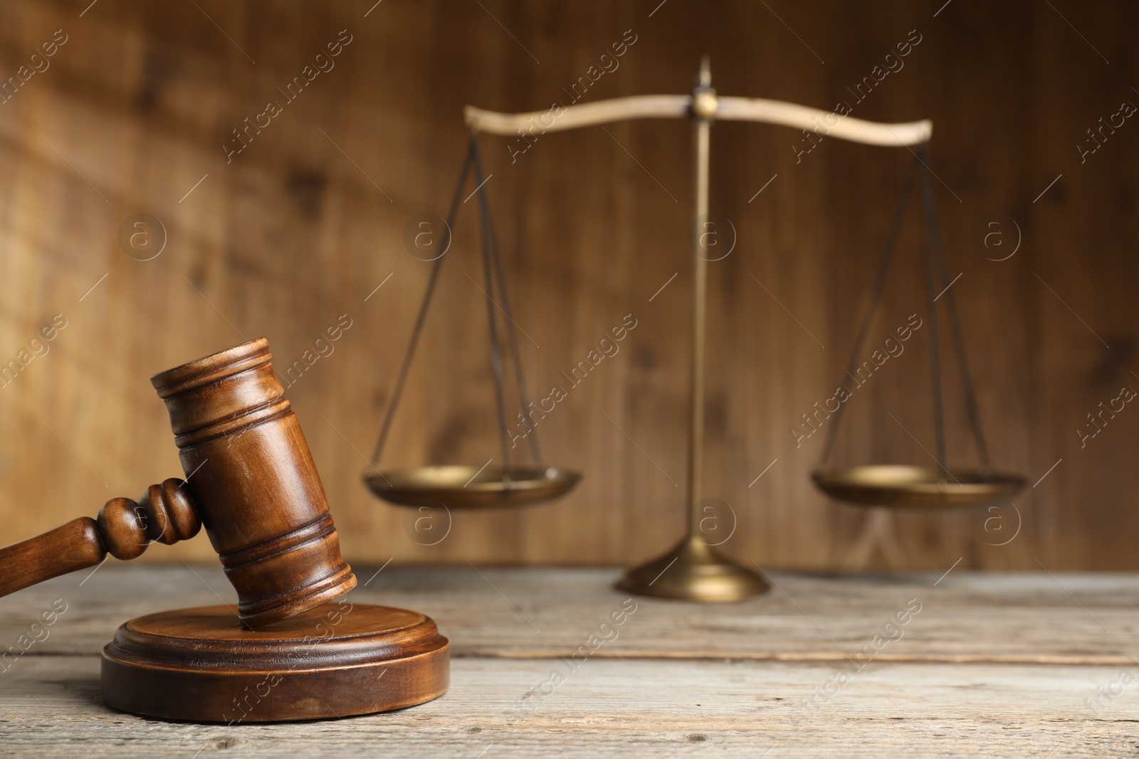 Photo of Gavel and scales of justice on wooden table, selective focus