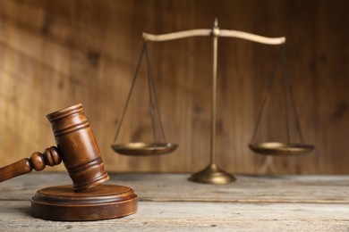 Photo of Gavel and scales of justice on wooden table, selective focus