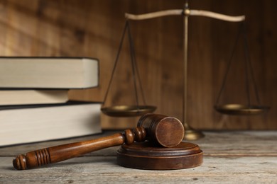 Photo of Gavel, scales of justice and books on wooden table, selective focus