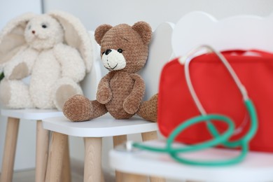 Photo of Pediatrician concept. Toys, medical bag and stethoscope on chairs in clinic, selective focus