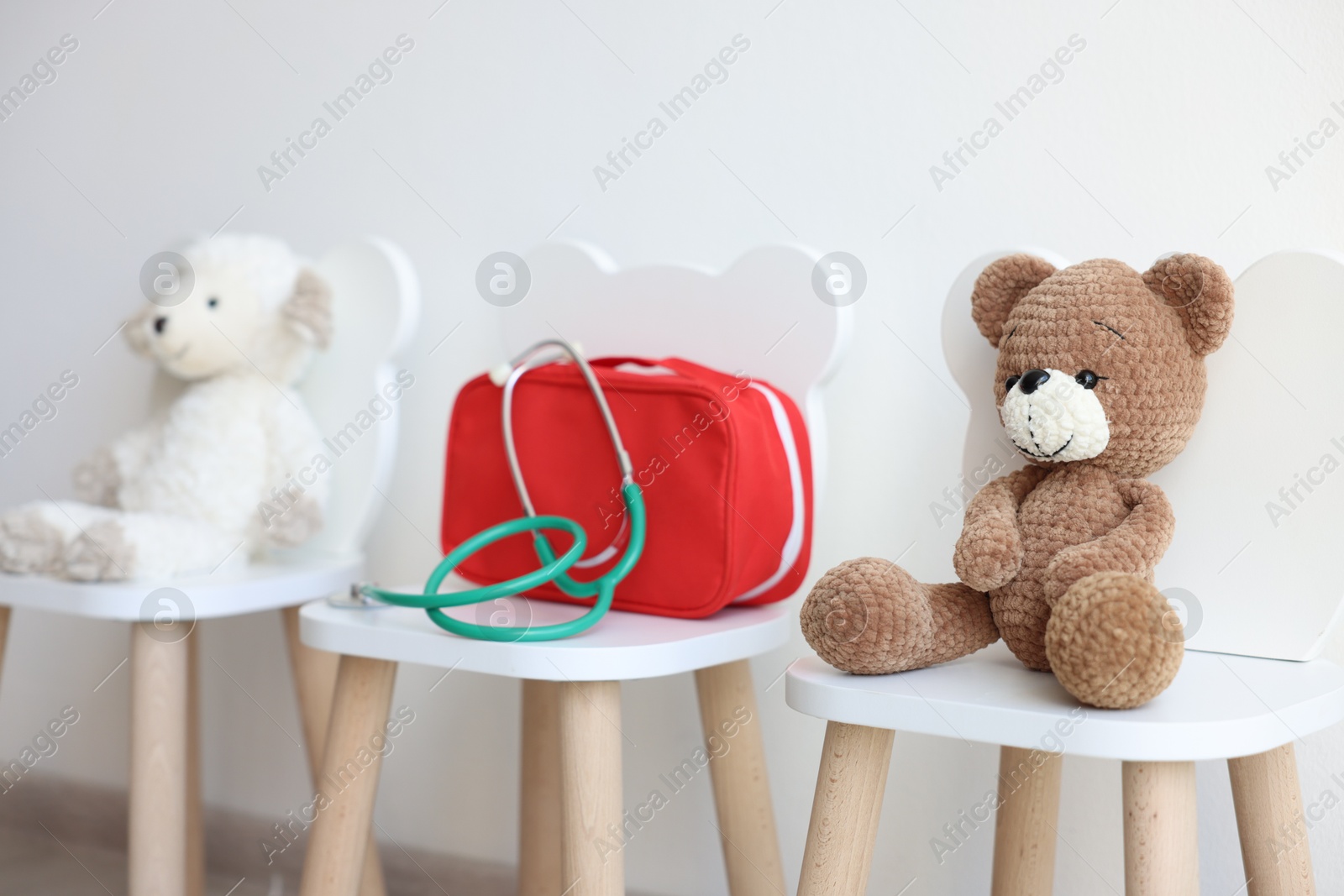 Photo of Pediatrician concept. Toys, medical bag and stethoscope on chairs in clinic