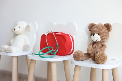 Photo of Pediatrician concept. Toys, medical bag and stethoscope on chairs in clinic