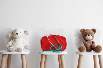 Photo of Pediatrician concept. Toys, medical bag and stethoscope on chairs in clinic