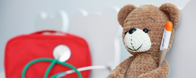 Photo of Pediatrician concept. Toy bear, thermometer, medical bag and stethoscope on chairs in clinic, closeup. Space for text