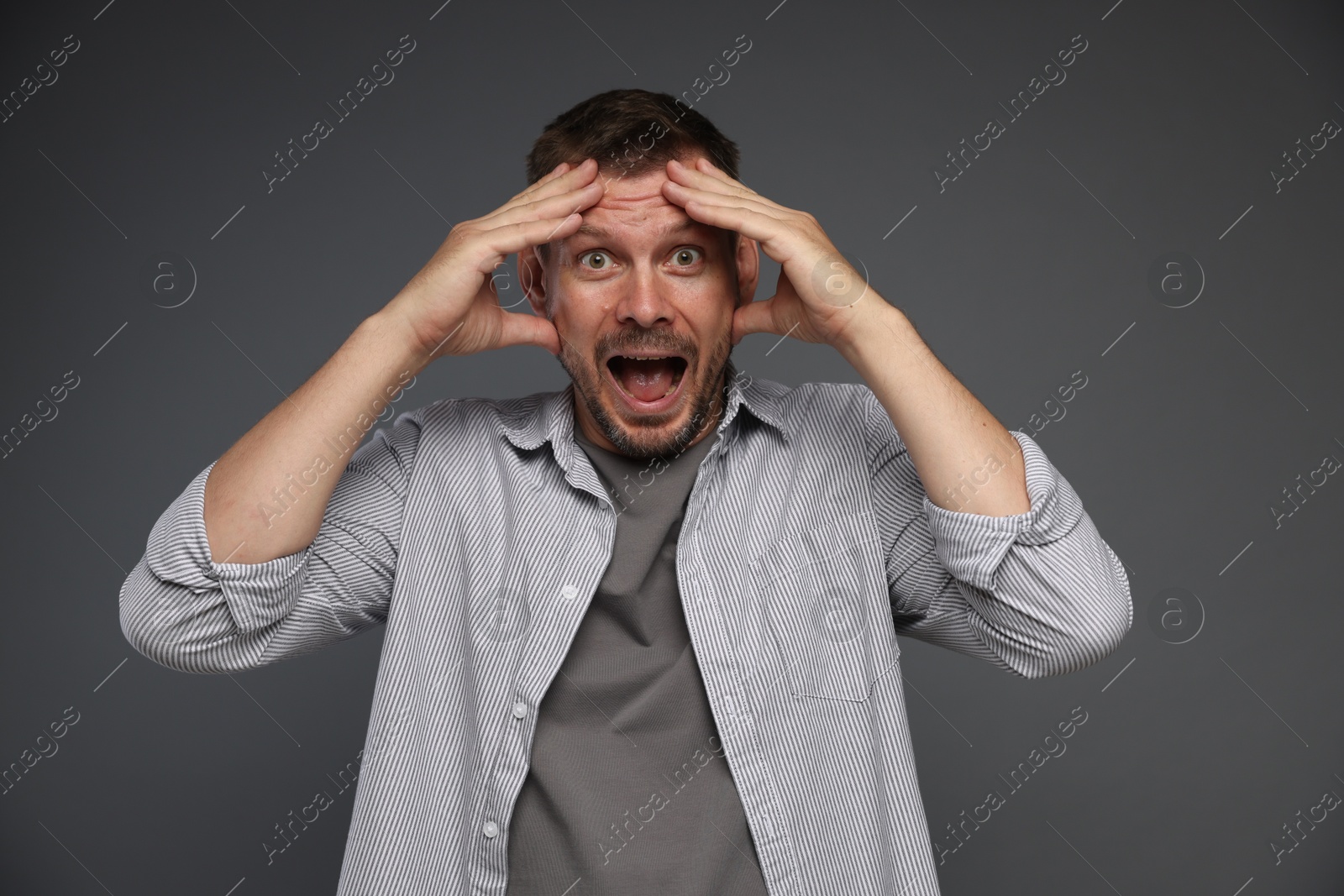 Man suffering from panic attack on grey background Photo of Man suffering from panic attack on grey background