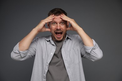 Photo of Man suffering from panic attack on grey background