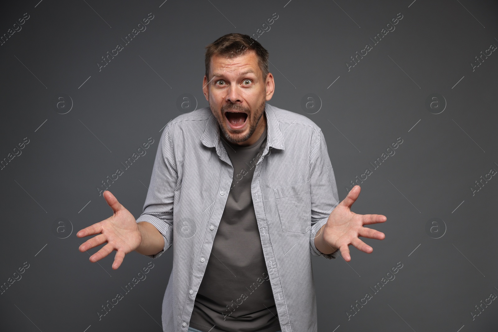 Man suffering from panic attack on grey background Photo of Man suffering from panic attack on grey background