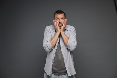 Photo of Man suffering from panic attack on grey background