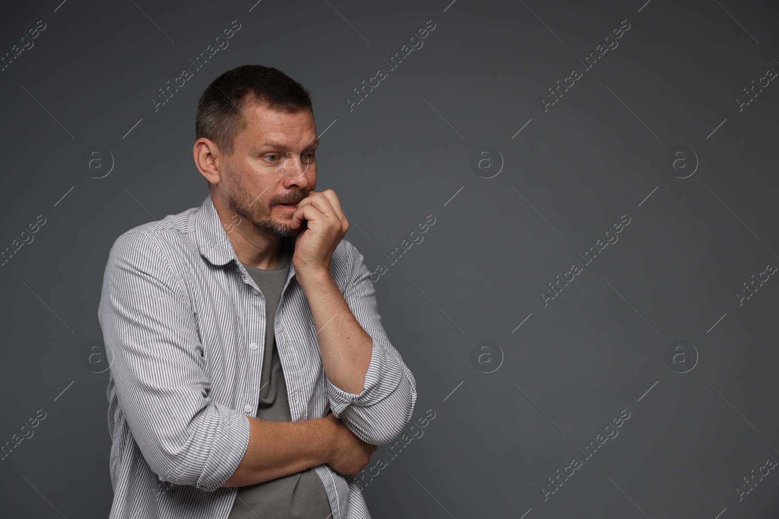 Man suffering from panic attack on grey background, space for text Photo of Man suffering from panic attack on grey background, space for text