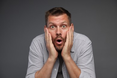 Photo of Man suffering from panic attack on grey background