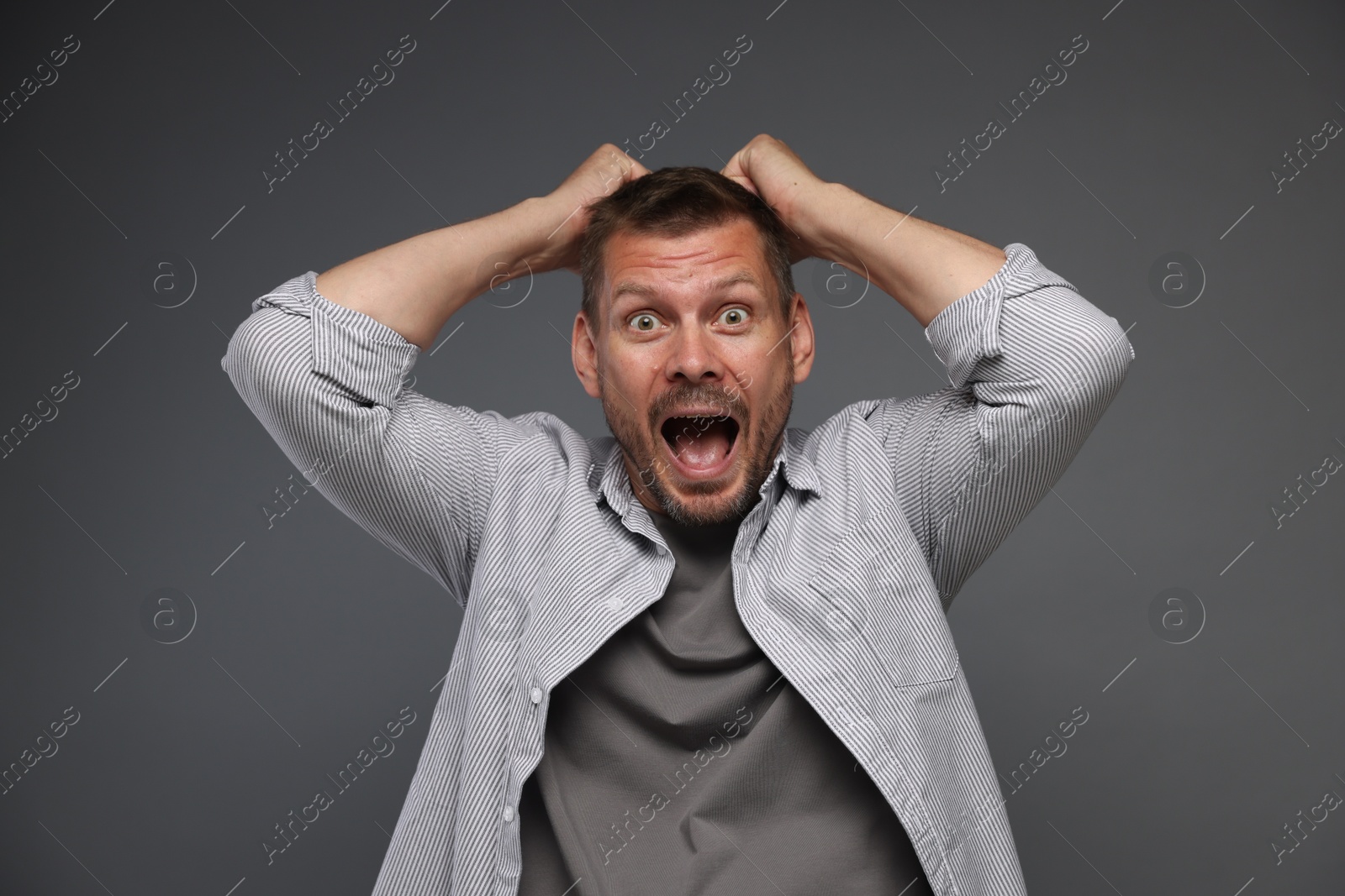 Man suffering from panic attack on grey background Photo of Man suffering from panic attack on grey background