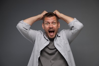 Photo of Man suffering from panic attack on grey background