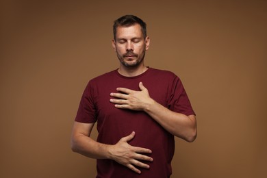 Photo of Panic attack. Man breathing to calm down on brown background