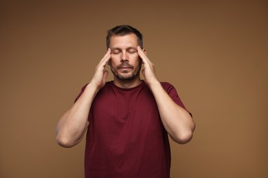 Photo of Panic attack. Man calming himself down on brown background