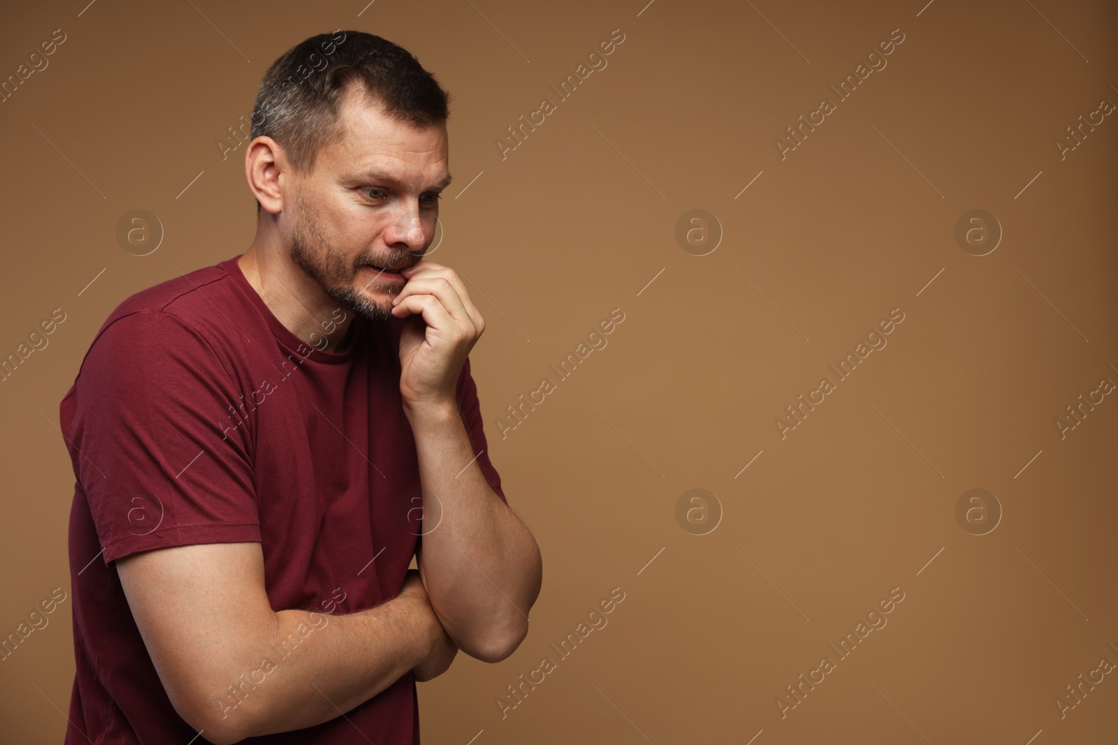 Man suffering from panic attack on brown background, space for text Photo of Man suffering from panic attack on brown background, space for text