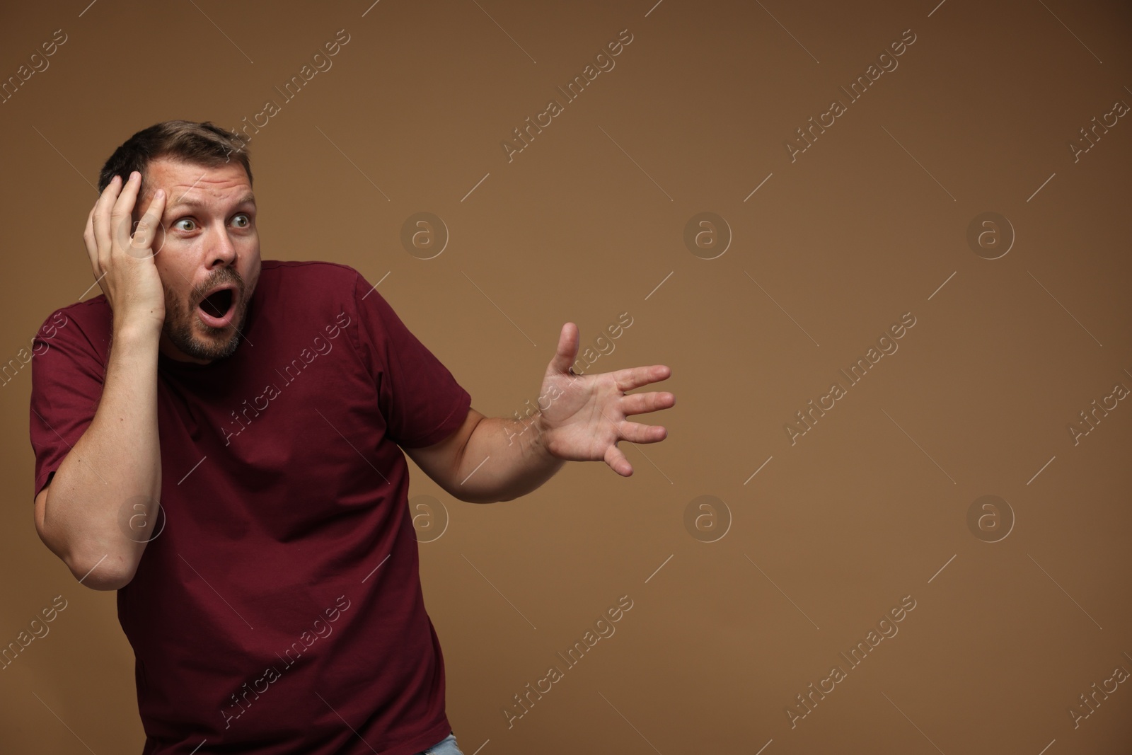 Man suffering from panic attack on brown background, space for text Photo of Man suffering from panic attack on brown background, space for text