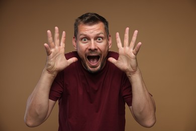 Photo of Man suffering from panic attack on brown background