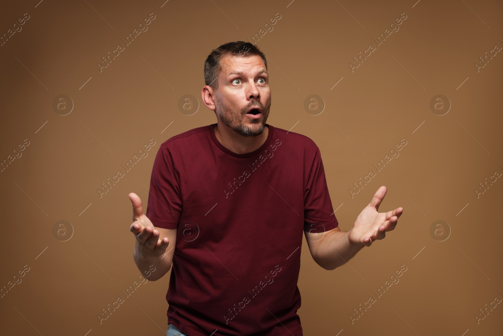 Man suffering from panic attack on brown background Photo of Man suffering from panic attack on brown background