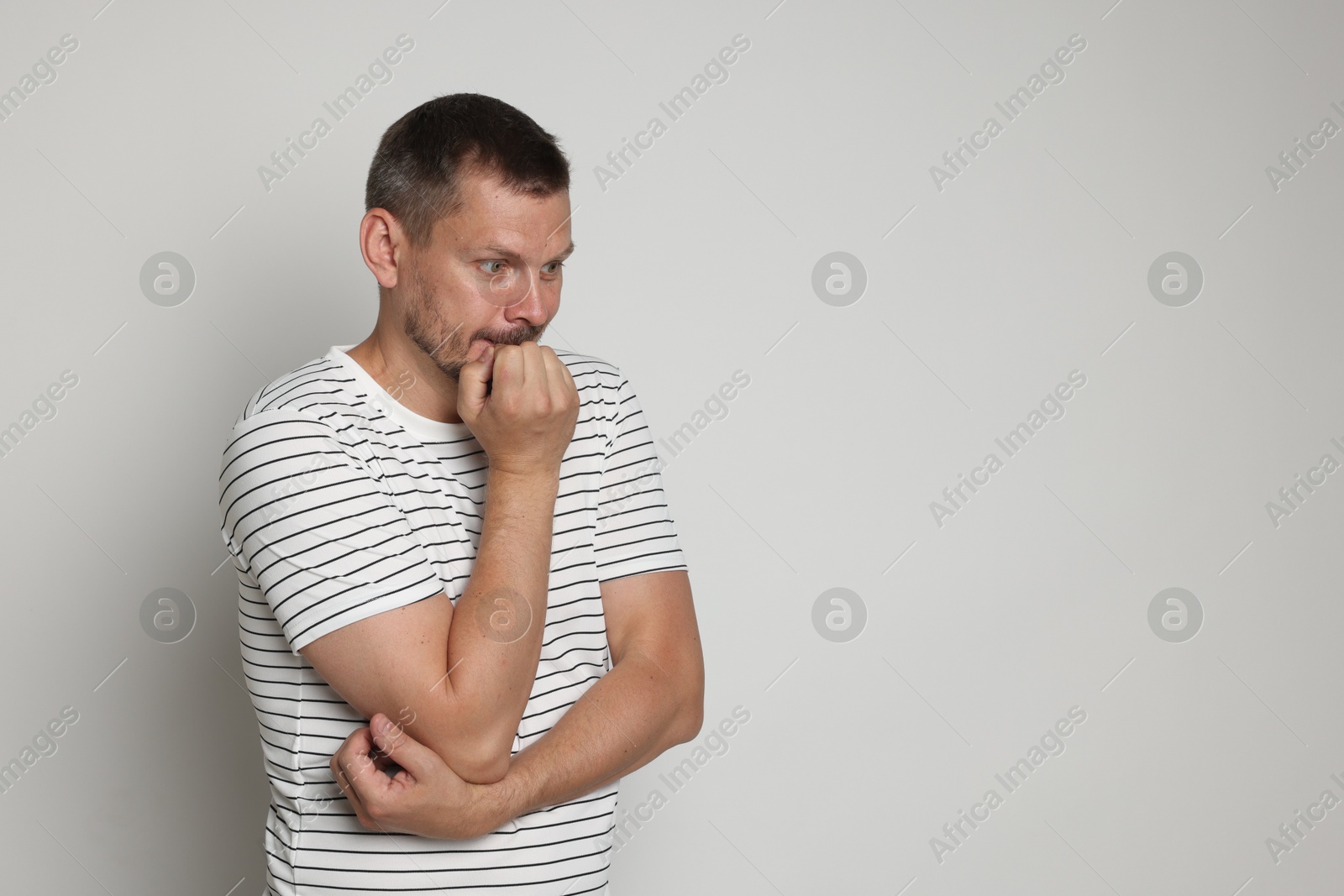 Man suffering from panic attack on light grey background, space for text Photo of Man suffering from panic attack on light grey background, space for text